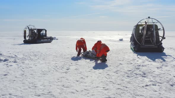 Rescuers Transporting Victim on Stretchers on Ice in Arctic