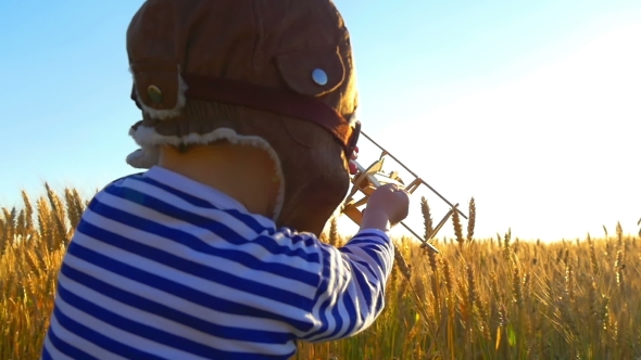 Happy Kid Playing with Toy Airplane Against Summer Sky Background