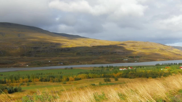 Sun-drenched Fields in Autumn in Iceland, Shadows From Clouds Is Moving Over Mountain Slopes