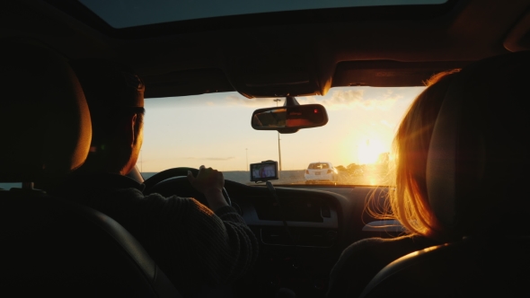 A Young Multi-ethnic Couple Is Driving To the Car in a Sunset. The Light Beautifully Illuminates the