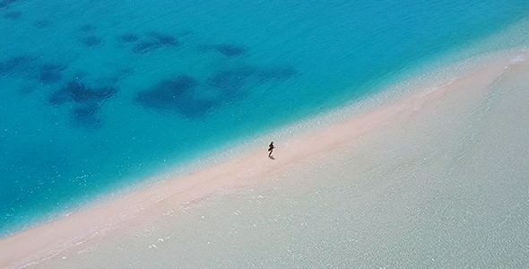 Woman Running Along Incredible Sandbank in the Maldives Surrounded by Tropical Water