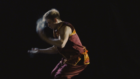 Young Man Training Wushu Against Black Background