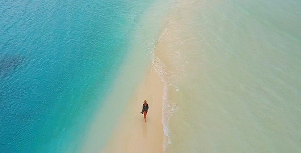Aerial of Woman Walking Down Incredible Sand Bar Surrounded by Tropical Water