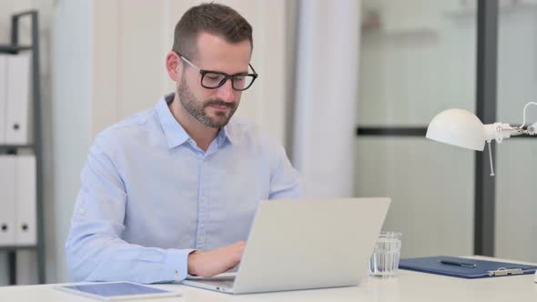 Middle Aged Man Using Laptop at Work