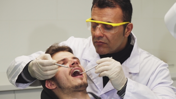 of a Professional Dentist Examining Teeth of His Patient