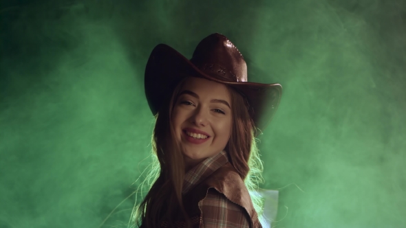 Cowboy Girl Unfolds Stares Into the Distance and Smiles. Smoke Background