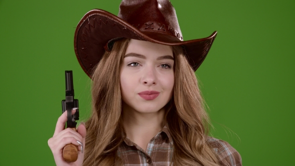 Sheriff Girl Holds a Revolver in Her Hands and Aiming at the Villain. Green Screen.