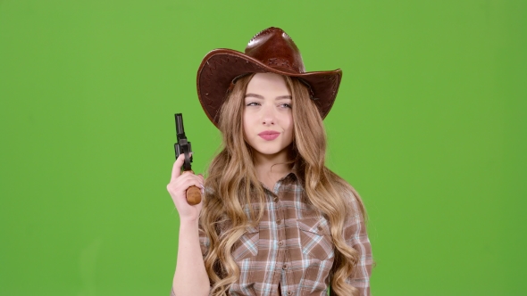 Sheriff Girl Holds a Revolver in Her Hands and Aiming at the Villain. Green Screen