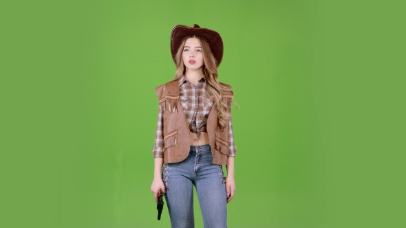 Cowgirl Holds a Revolver in Her Hands and Aiming at the Villain. Green Screen