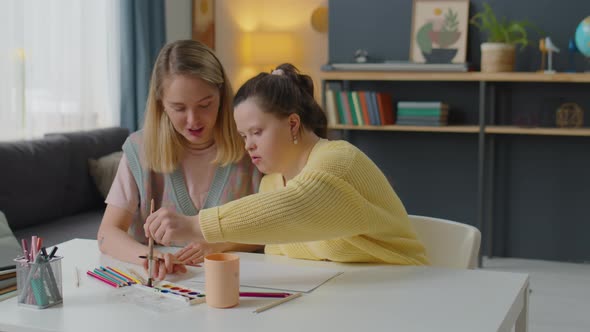 Girl with Down Syndrome Having Art Class with Teacher