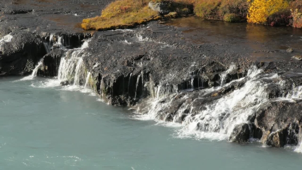 Clear Water Is Flowing From Rocks Into Rapid Mountain River Light Blue Colored