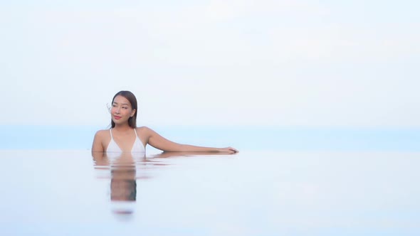 Young asian woman enjoy around outdoor swimming pool for leisure