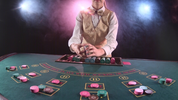 Casino Stickman Woman Distributes Cards on the Poker Table Top. Black Background. Smoke.