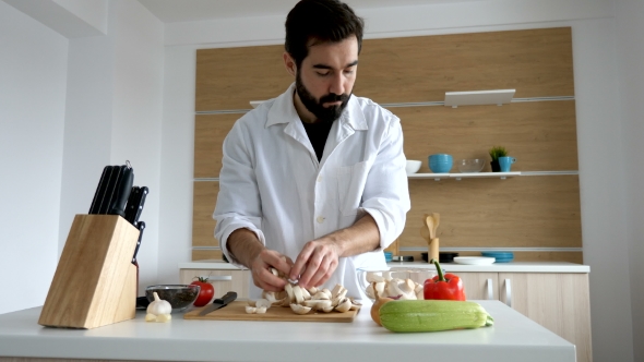 Cook in Modern Kitchen Putting Cut Mushrooms in a Bowl