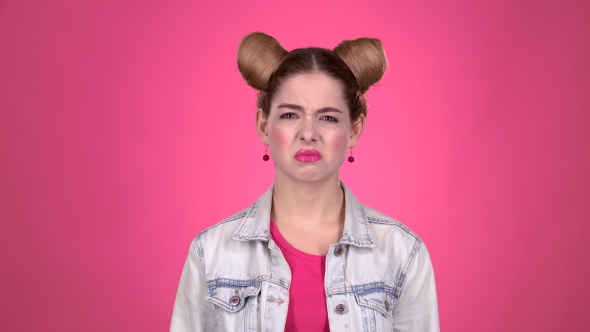 Teen Shows a Thumbs Down, She's Upset. Pink Background