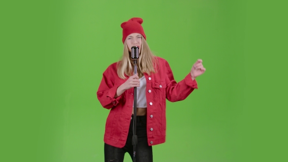 Teenager Sings on Stage in a Retro Microphone. Green Screen