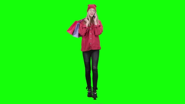Teenager Comes with Bags in His Hands and Talks on the Phone. Green Screen