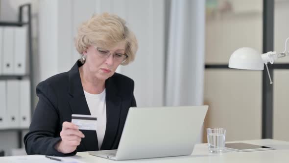 Old Businesswoman Excited By Online Shopping Success on Laptop
