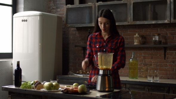 Lovely Woman Making Smoothie in Blender in Kitchen