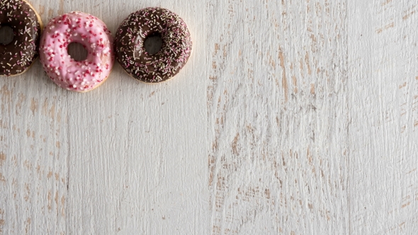 Stop Motion of Donuts on White Wooden Background