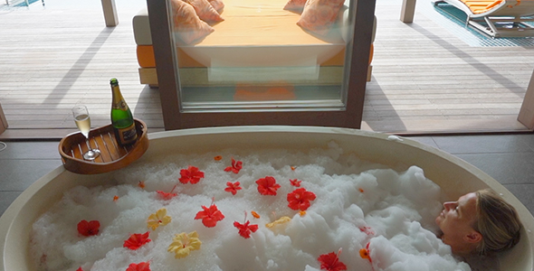 Beautiful Girl Sitting in Tropical Flower Bath