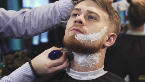Barber Applying Shaving Cream on the Beard of His Client