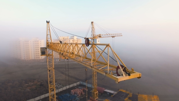 Construction Site in the Fog with a Bird's Eye with Tower Cranes on the Sunset.