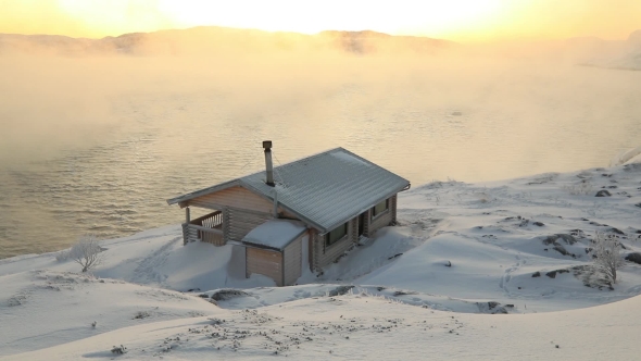 Wooden Cottage on the Winter Seashore at Dawn