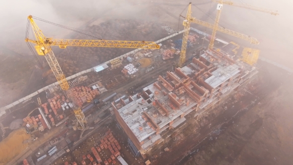 Construction Site in the Fog with a Bird's Eye with Tower Cranes on the Sunset.