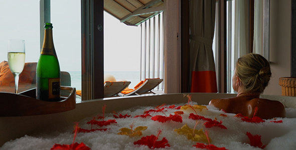 Girl Lying in Flower Filled Bubble Bath at Luxury Resort