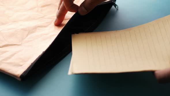 Putting Paper in a Bag on Table