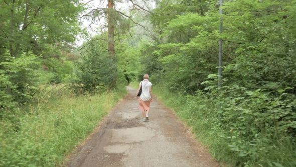 Young Woman Walks in the Park