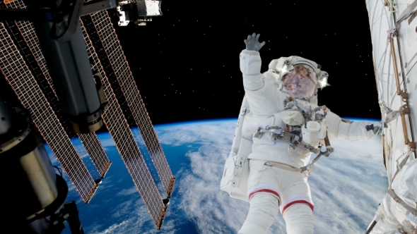 Astronaut Working on Space Station Above the Earth alt