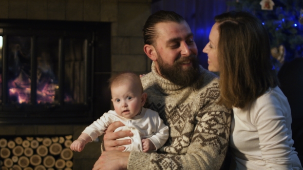 Young Happy Family with Infant Celebrating Christmas