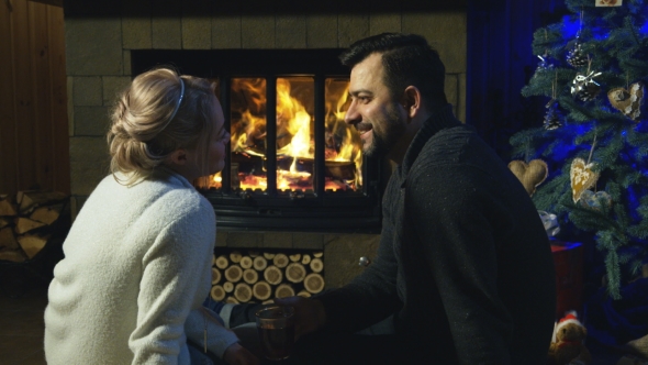 Loving Couple at Fireplace Before Christmas