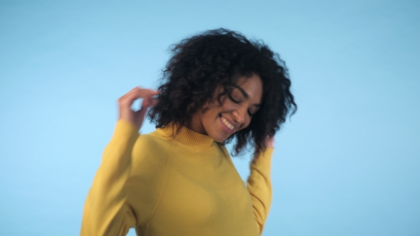 Mixed Race Black Woman Portrait with Big Afro Curly Hair on Blue Background Dancing and with