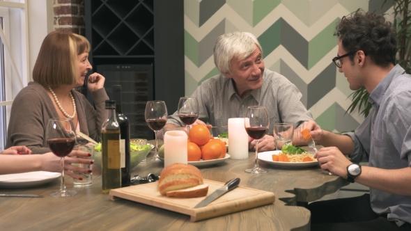 Cheerful Family Communicates at Dinner Table