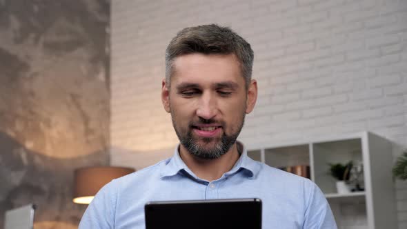 Close Up Smiling Businessman Uses Tablet at Home Office