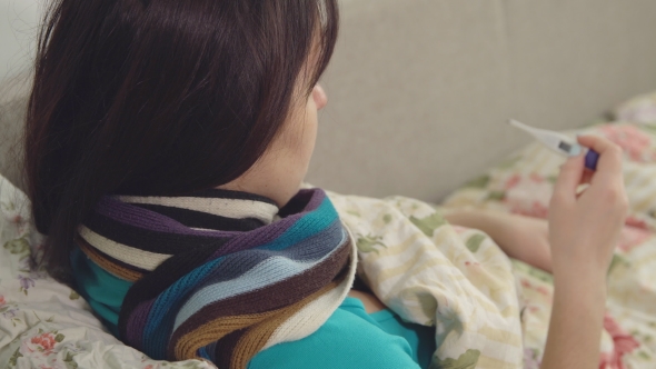 Sick Woman with Thermometer To Measure Body Temperature