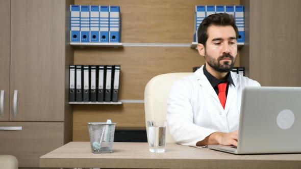 Doctor in His Office at the Laptop