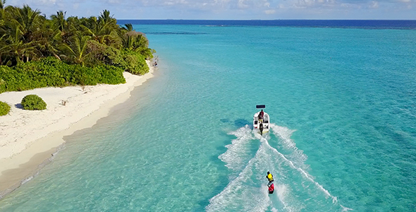 Water Skier and Jet Skier Racing in Front of Beautiful Tropical Island