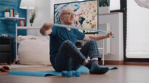 Old Man Using Resistance Band to Stretch and Pull