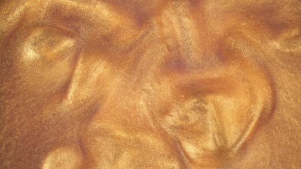 Gold Ink Reacting in Water Creating Abstract Background