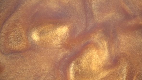 Gold Ink Reacting in Water Creating Abstract Background