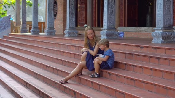 Steadycam Shot of a Young Woman and Her Son Visiting a Budhist Temple Ho Quoc Pagoda on Phu Quoc