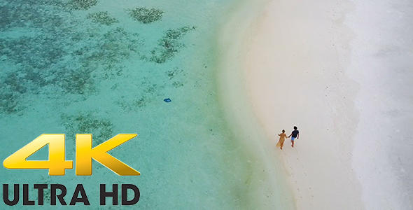 Couple Walking Along Beach on Luxurious Tropical Island