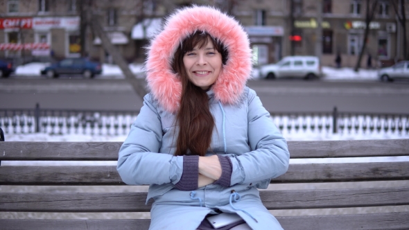 Portrait of a Young Woman on a Bench Outside on a Winter Day