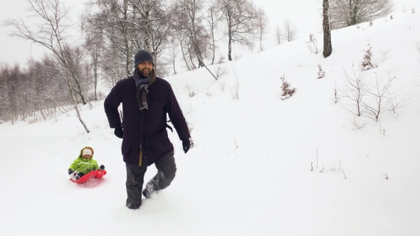 Winter Front Follow Father Pulling Red Bobsled on Snowy Field with Child. Dad, Son or Daughter