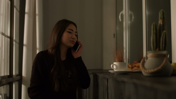 Joyful Asian Young Woman Chatting on Cellphone