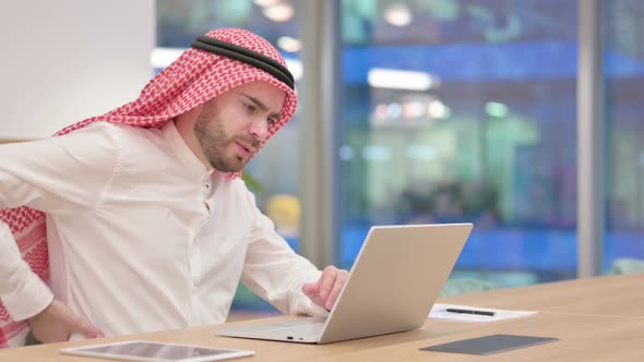 Tired Arab Businessman with Laptop Having Back Pain in Office 